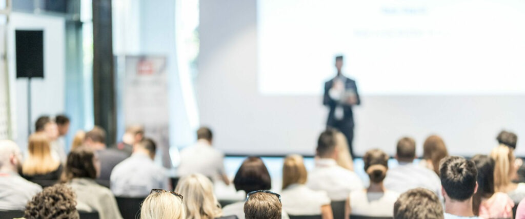 Male business speaker giving a talk at business conference event.