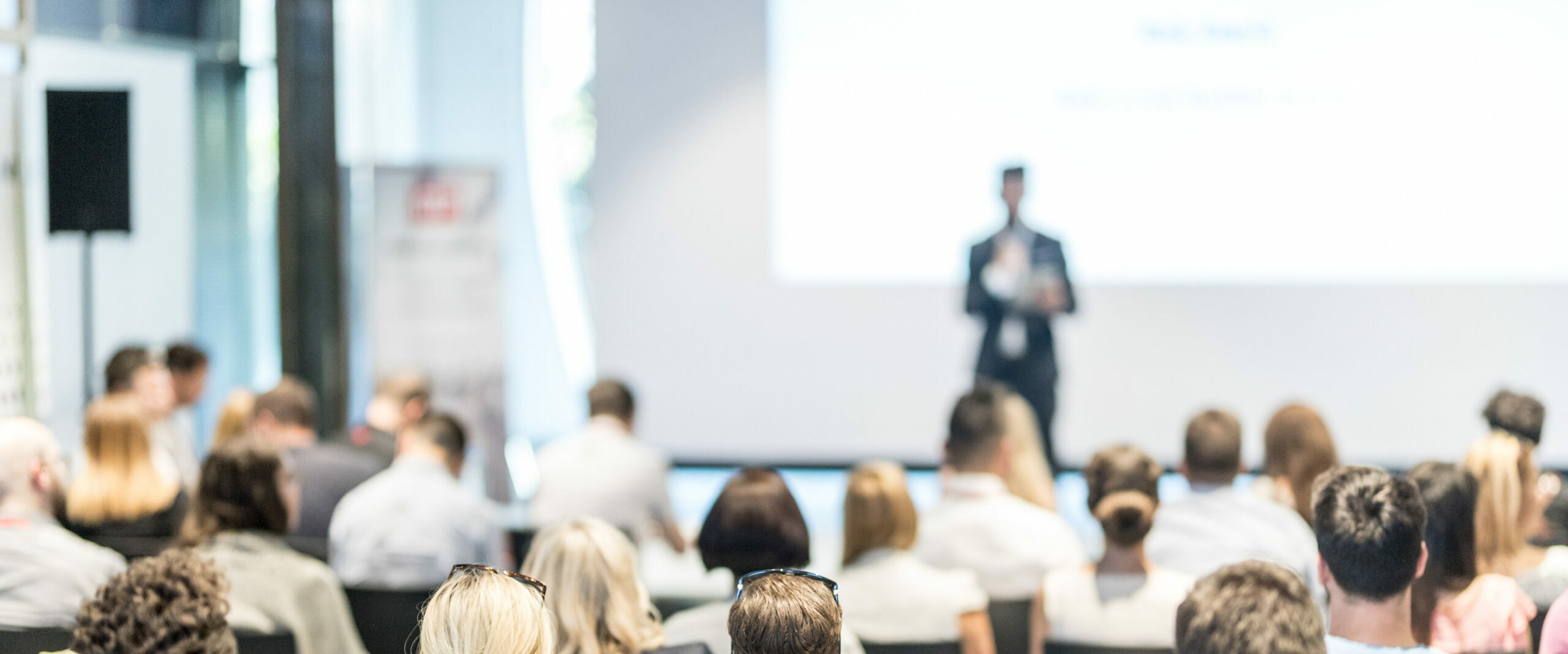 Male business speaker giving a talk at business conference event.